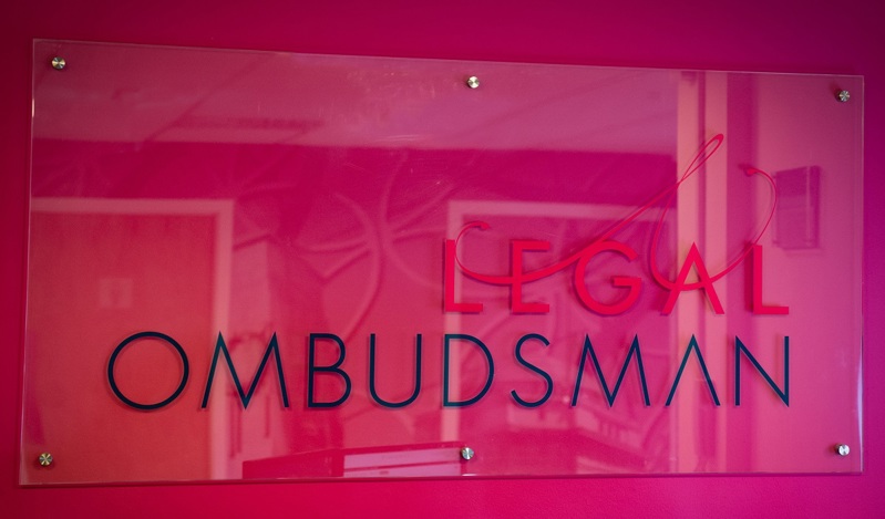image of welcome board at the Legal Ombudsman against a pink wall