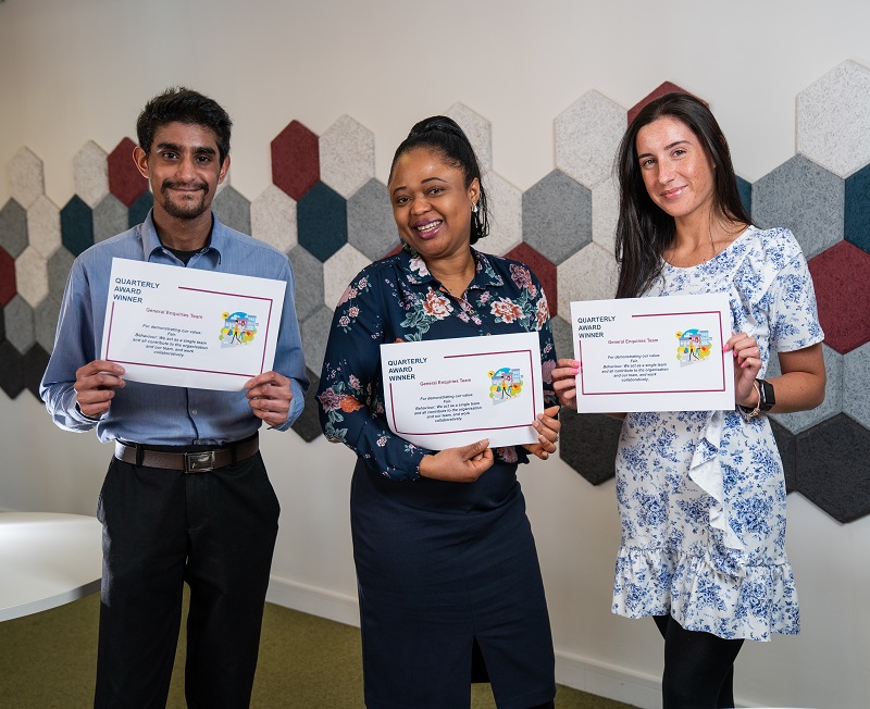 male and two females holding up award certificates