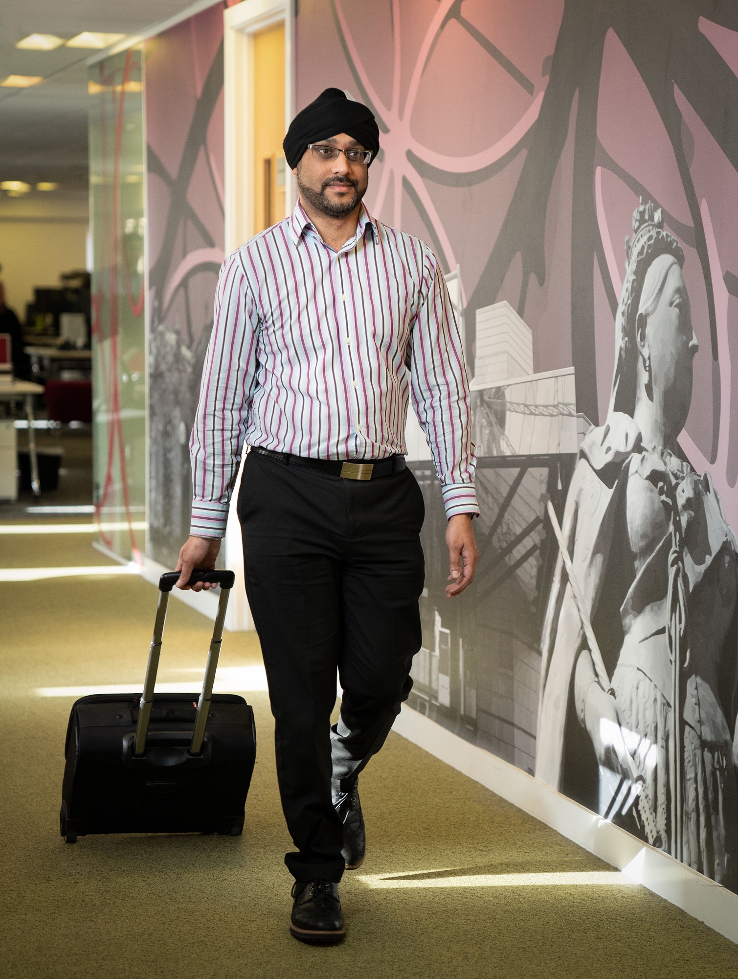 professional male walking down office corridor