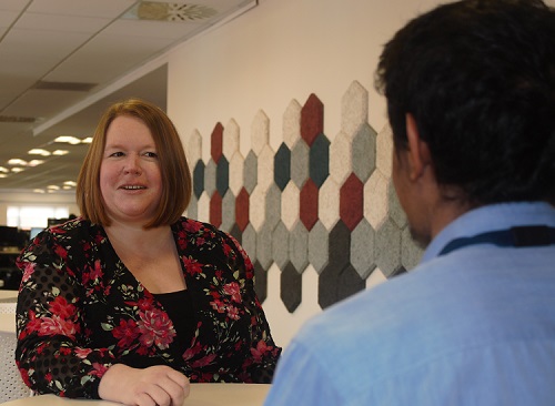 professional woman talking to a man at a table.