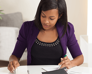 woman looking down at files on a desk